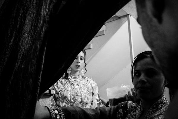 A young woman, very elegant in her beige dress decorated in gold and pearls, makes her entrance under the applause and ululation. Her future husband welcomes her and together they cross the crowd of women in sequined dresses and men in suits, joining a huge golden sofa sat on a platform. In this uptown neighborhood near Marseille, the celebration can begin.